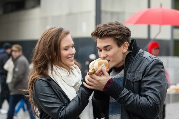 Frau füttert Mann mit Hotdog — Stockfoto