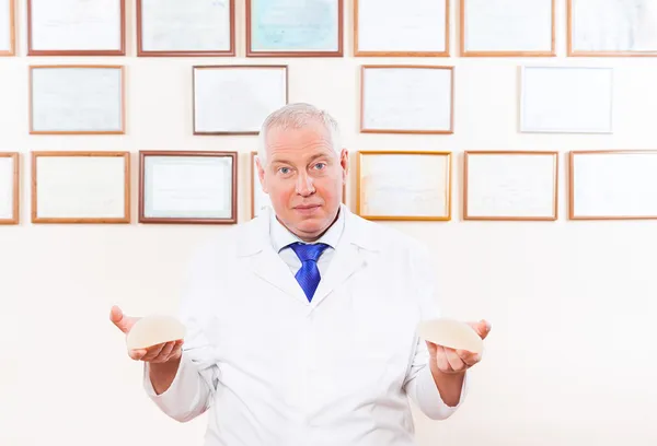 Doctor showing silicone breast implants — Stock Photo, Image