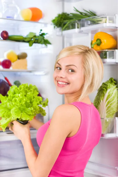 Vrouw houdt groene salade — Stockfoto