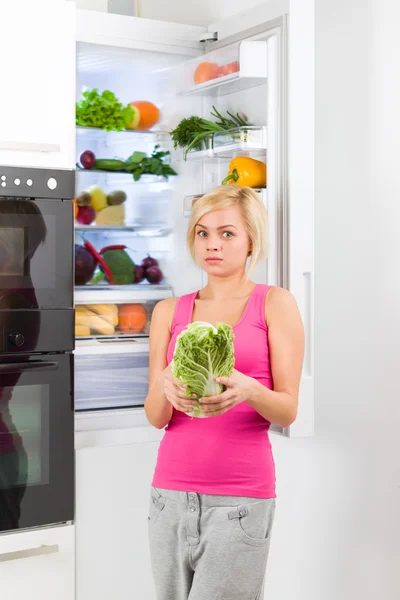 Unhappy woman with green cabbage — Stock Photo, Image