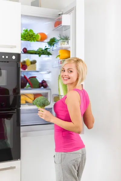 Frau hält Brokkoli in der Hand — Stockfoto