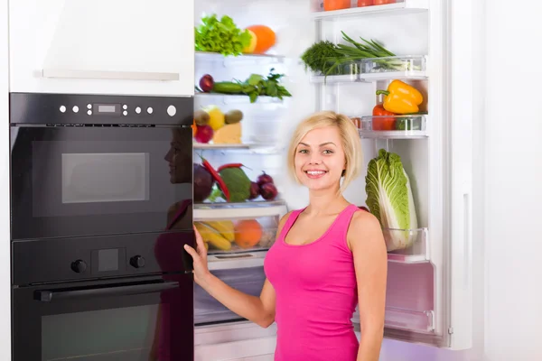 Kvinna öppna kylskåpsdörren — Stockfoto