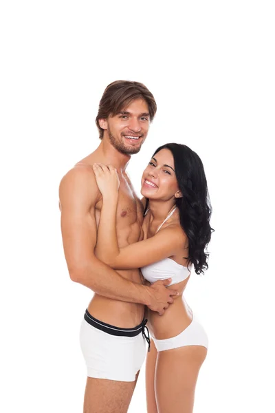 Улыбающаяся пара в купальниках, обнимающая — стоковое фото