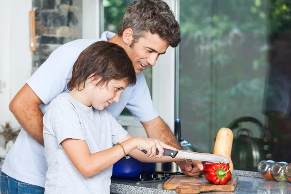 Father son kitchen, slicing vegetables — Stock Photo, Image