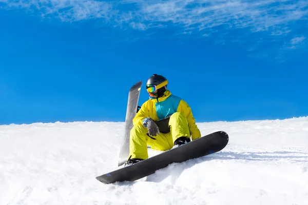 Snowboarder sitting on snow mountains — Stock Photo, Image