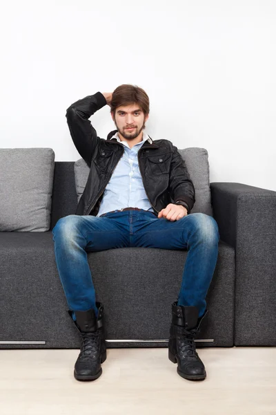 Hombre sentado en el sofá en la sala de estar — Foto de Stock