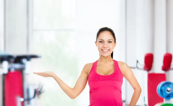 Fitness girl showing open palm — Stock Photo, Image