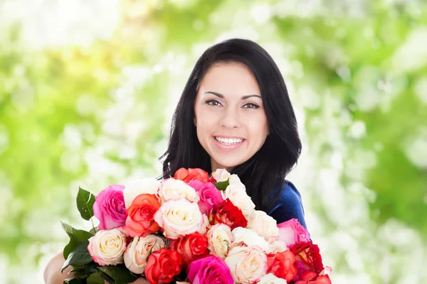 Vacker kvinna med stora rosor — Stockfoto