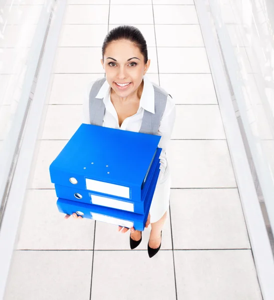 Kobieta trzymać niebieski stos folderów — Zdjęcie stockowe