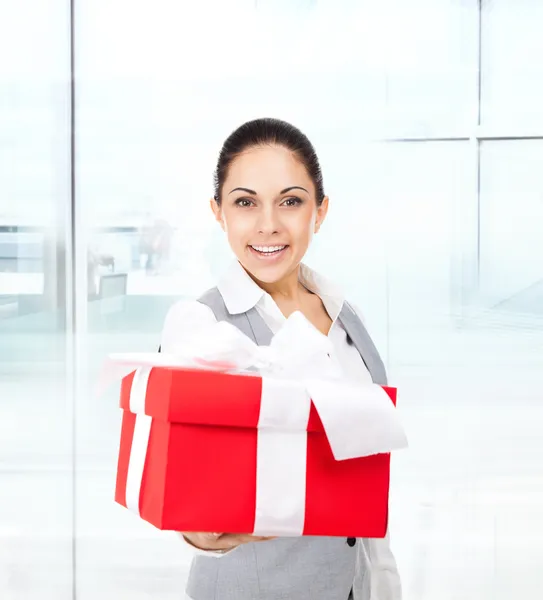 Mujer de negocios sostiene caja de regalo roja — Foto de Stock