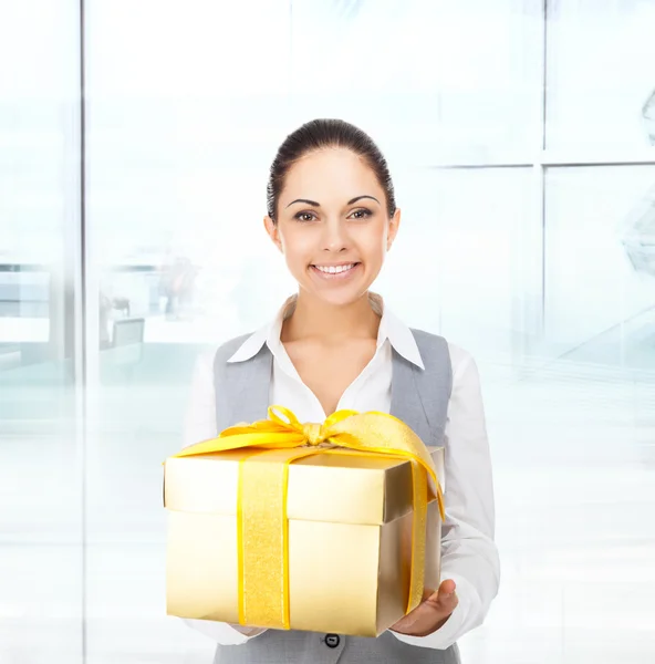 Empresaria sostiene caja de regalo de oro — Foto de Stock