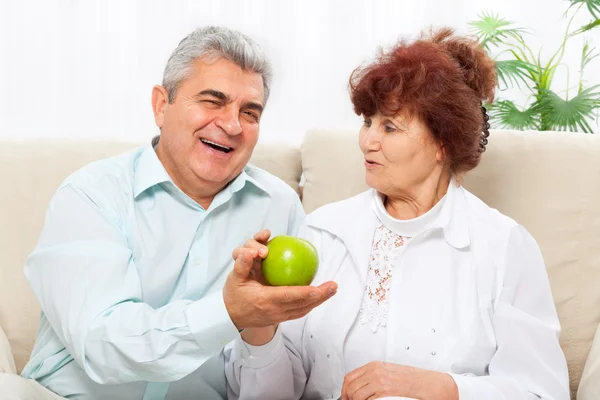 Старшая пара держит зеленое яблоко — стоковое фото