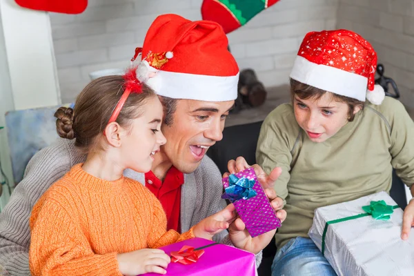 Vater mit zwei Kindern öffnet Weihnachtsgeschenke — Stockfoto