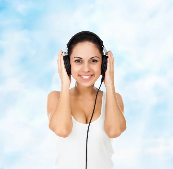 Женщина в наушниках слушает музыку — стоковое фото