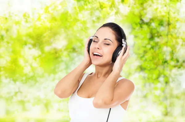 Woman in headphones listens to music — Stock Photo, Image