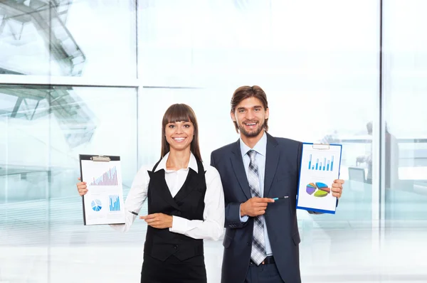 Successful business couple holding clipboards — Stock Photo, Image