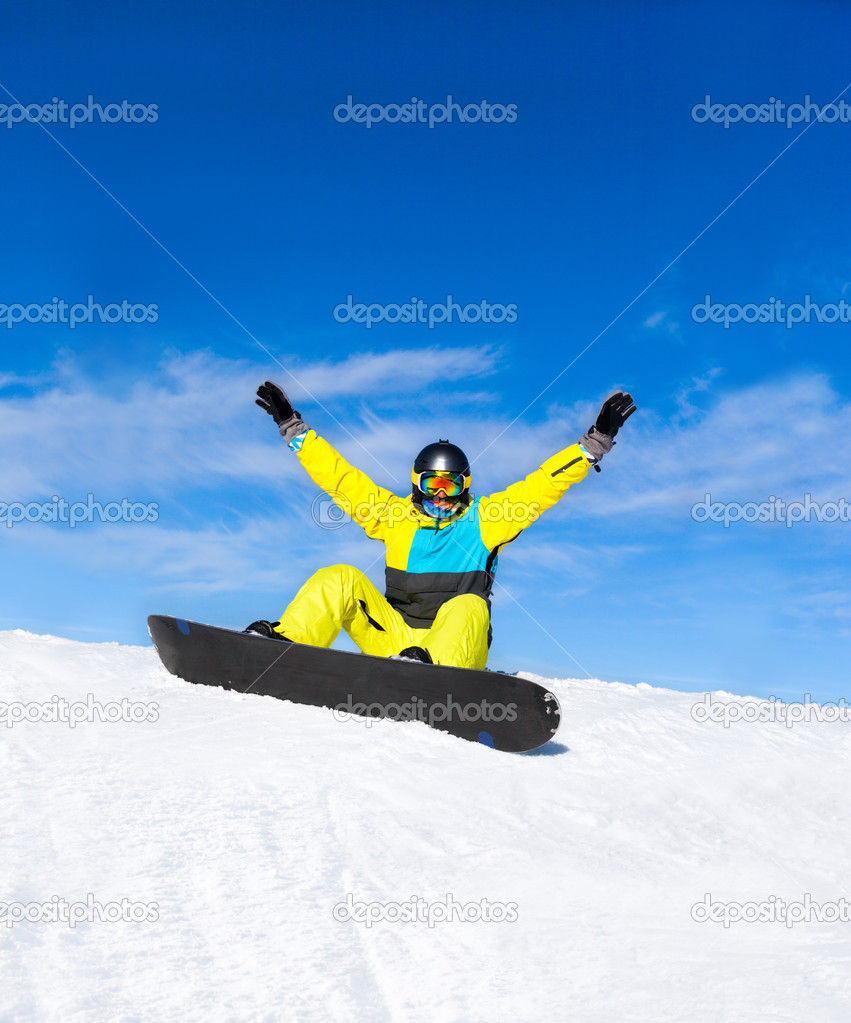Snowboarder sitting on snow mountain slope