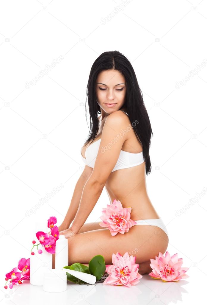 Woman among lotus flowers with cosmetic