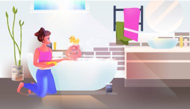 Genç bir kadın küçük kızını banyo banyosunda yıkıyor. İç kısımları ise tam boy.