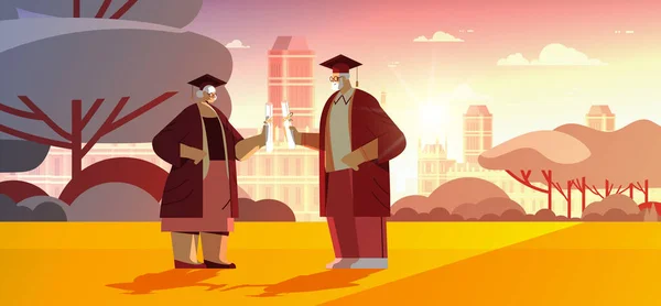 Starsi absolwenci w czapkach dyplomowych spacerujących po parku absolwenci w podeszłym wieku świętujący dyplom — Wektor stockowy