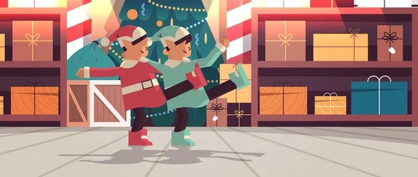 Elfen in uniform hebben plezier santa helpers paar vieren gelukkig nieuwjaar vrolijk kerstvakantie workshop interieur — Stockvector