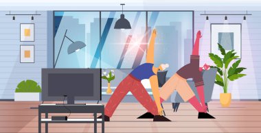 Son sınıf erkek kadın yoga egzersizleri yapıyor. İnternetten özel ders seyrediyor. Sağlıklı yaşam tarzı eğitimi veriyor.