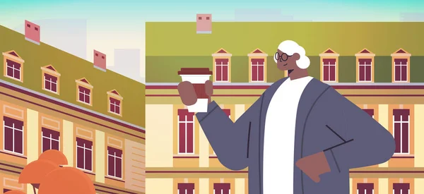 Afrikansk amerikansk kvinna dricker kaffe senior dam med kaffe paus stadslandskap bakgrund horisontellt — Stock vektor