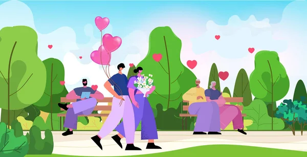 Любящая пара празднует День Святого Валентина в парке мужчина женщина влюблена стоя вместе с цветами и розовыми воздушными шарами — стоковый вектор