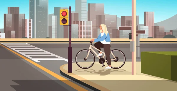 年轻女子骑自行车的人等着绿灯在过马路时骑自行车的女孩健康的生活方式 — 图库矢量图片