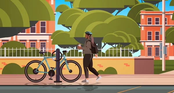 자전거타는 여자가 자전거타는 도중 헬멧을 쓴 채 자전거 옆에서 서 커피 잔을 들고 쉬고 있는 모습 — 스톡 벡터