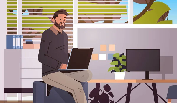 Бизнесмен работает на ноутбуке бизнес-человек фрилансер с помощью ноутбука на рабочем месте современный интерьер офиса — стоковый вектор