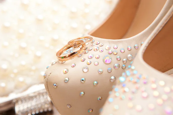 Trouwringen op schoenen van de bruid — Stockfoto