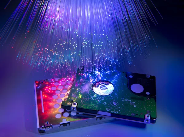 Computer harddisk and heads on technology fiber optics background — Stock Photo, Image