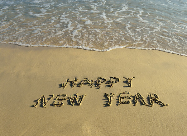 Happy new year written in the sand