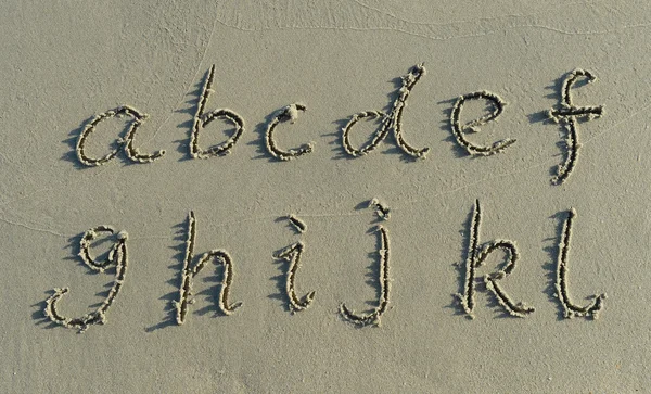 Alphabet-Buchstaben handgeschrieben im Sand am Strand — Stockfoto