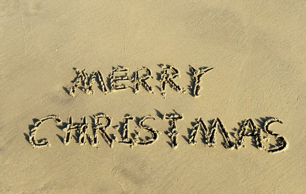 Buon Natale scritto a mano in sabbia su una bella spiaggia — Foto Stock