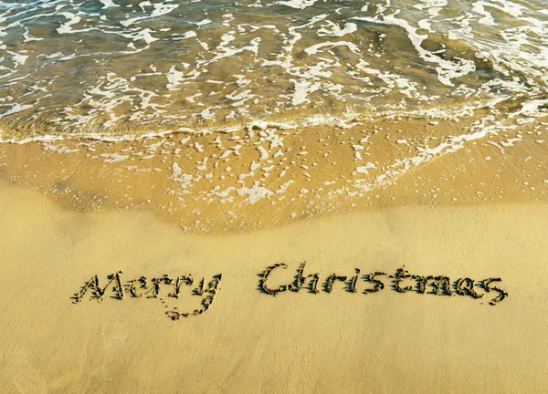 Frohe Weihnachten handgeschrieben im Sand am Strand — Stockfoto