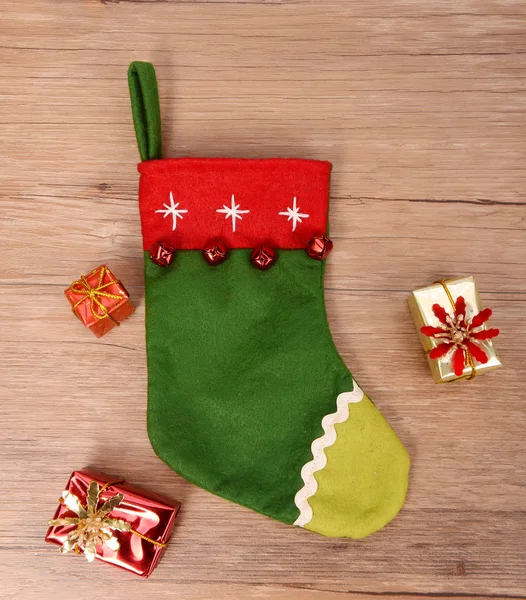 Christmas sock with gifts on wooden background — Stock Photo, Image