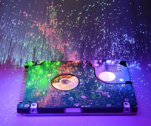 Computer harddisk and heads on technology fiber optics background — Stock Photo, Image