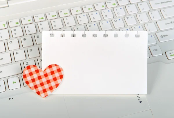 Röda hjärtan och fästis på laptop tangentbord — Stockfoto