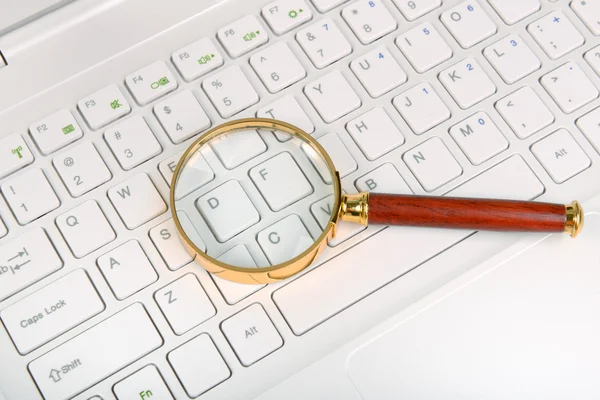 Magnifying glass on laptop computer Royalty Free Stock Photos