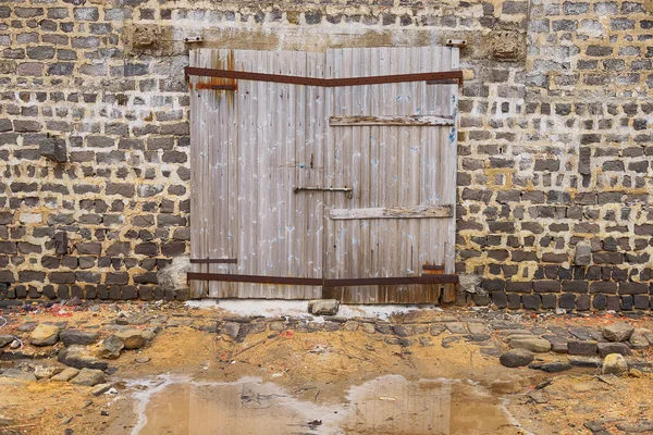 Стена из старинного деревянного сарая с дверью — стоковое фото