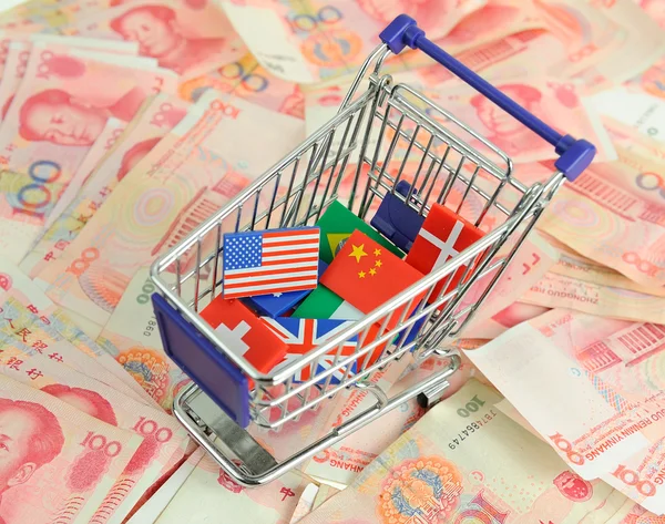 Shopping cart with national flag on a lot of Renminbi on white b — Stock Photo, Image