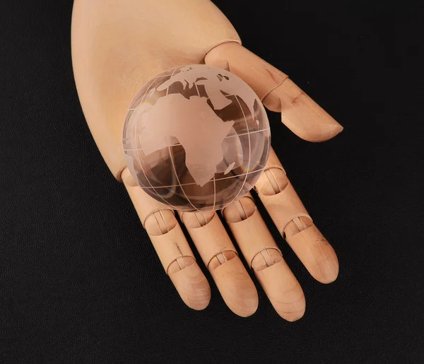 Wood hand and glass earth — Stock Photo, Image