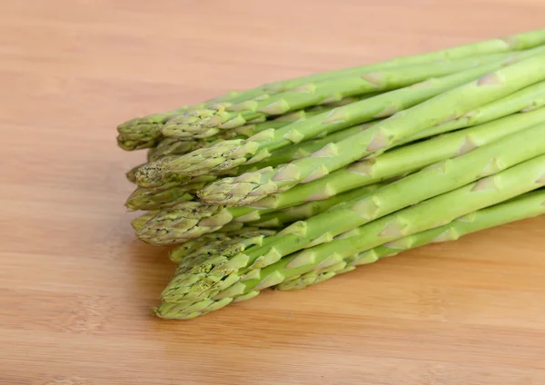 Pousses d'asperges vertes fraîches posées sur fond de bambou — Photo