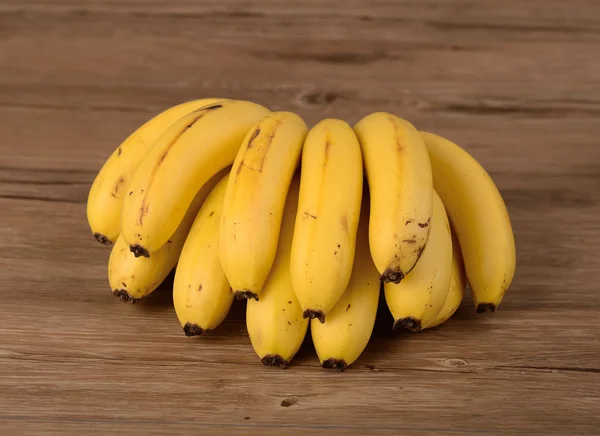 Gelbe Bananen auf hölzernem Hintergrund — Stockfoto