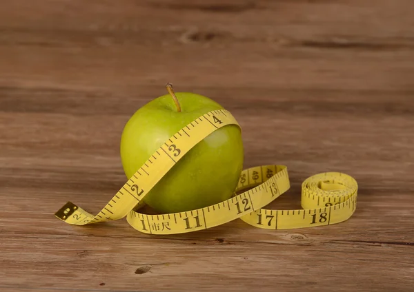 Concepto de dieta, manzana y cinta métrica sobre fondo de madera —  Fotos de Stock