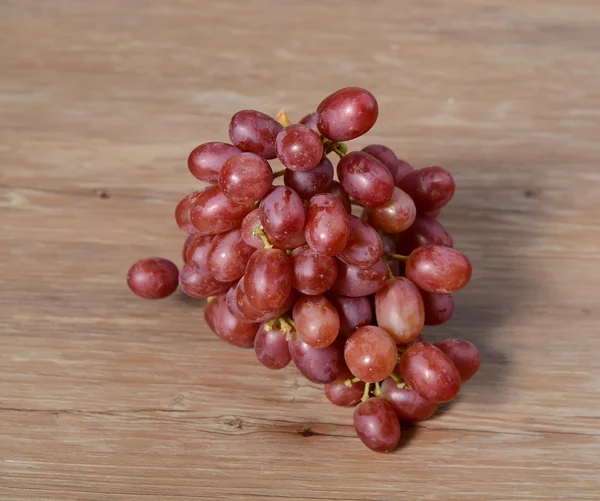 Uvas rojas sobre una mesa de madera —  Fotos de Stock