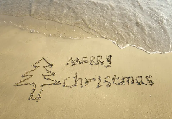 Frohe Weihnachten handgeschrieben in Sand an einem schönen Strand — Stockfoto