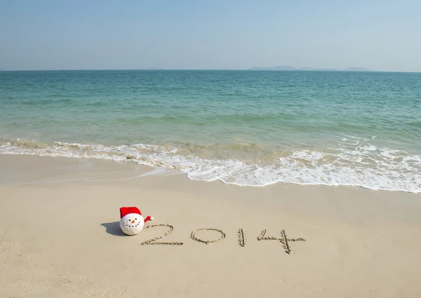 2014 with santa hat on sea beach sand with wave — Stock Photo, Image